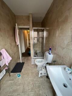 Tiled bathroom with a walk-in shower, pedestal ...