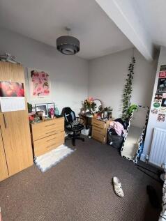 Bright bedroom with neutral walls, fitted stora...