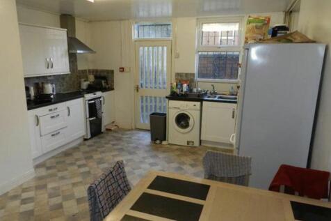 Bright, modern kitchen with white cabinetry, in...