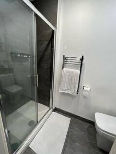 Modern bathroom with a glass-enclosed shower, w...