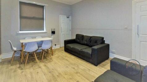 Bright, modern living area with light wood floo...