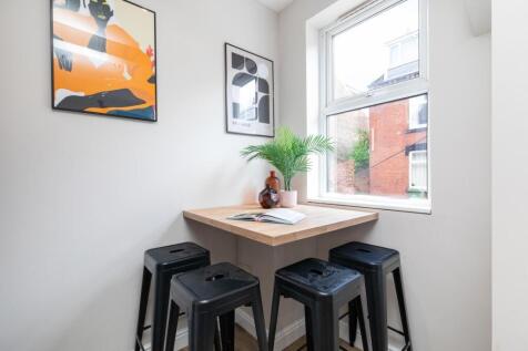 Bright eat-in kitchen nook with a wooden counte...