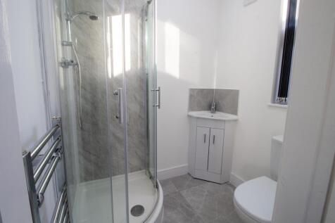 Bright, modern bathroom with a corner glass sho...
