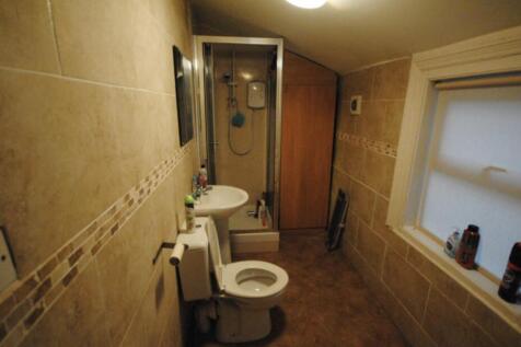 Well-finished bathroom with tiled walls, an enc...