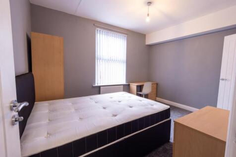 Bright, simply furnished bedroom with a double ...