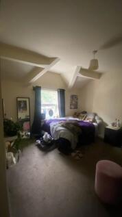 Bright bedroom with a double bed positioned ben...