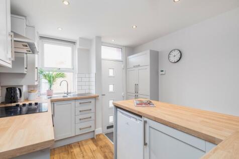 Bright, contemporary kitchen with white cabinet...
