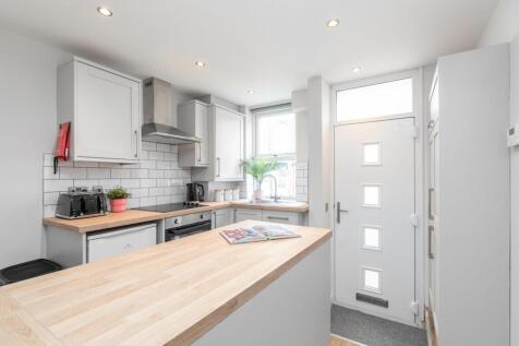 Bright modern kitchen with light wood counterto...