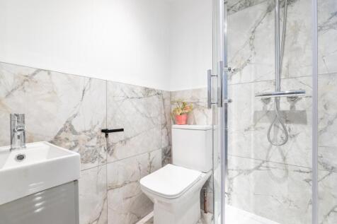 Bright, modern bathroom with marble-effect wall...