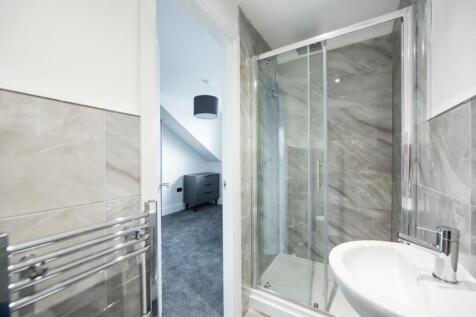 Modern en-suite bathroom featuring a glass show...