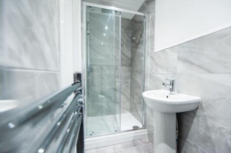 Modern bathroom with a walk-in glass shower cub...