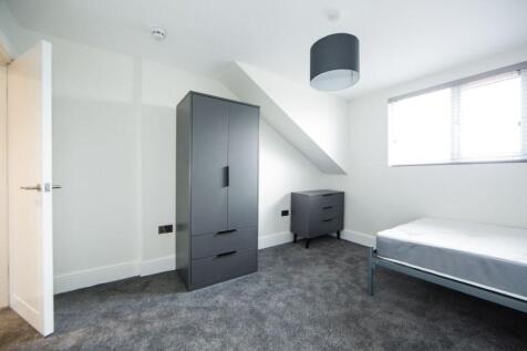 Bright, neutrally decorated bedroom with a sing...