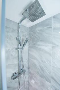 Modern tiled shower with large rainhead and sle...