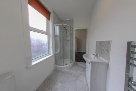Bright modern bathroom with a corner glass show...