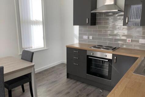 Modern kitchenette with sleek grey fitted units...