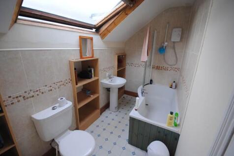 Bright attic bathroom with a bath and shower, p...
