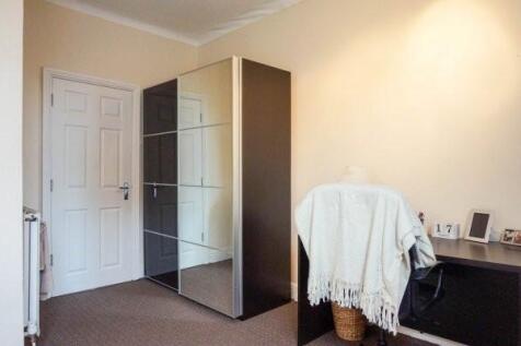 Neat bedroom with neutral walls, mirrored wardr...