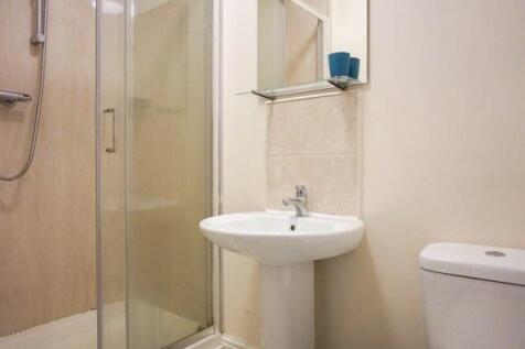 Bright, neutrally finished bathroom with a glas...