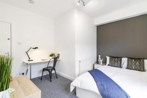 Bright, modern double bedroom with a neatly mad...