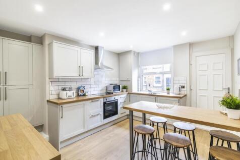 Bright, modern kitchen with pale cabinetry, int...