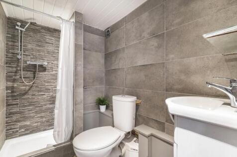Modern bathroom with tiled walls, a walk-in sho...