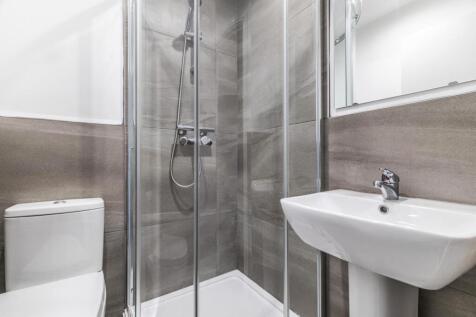 Modern bathroom with a glass-enclosed corner sh...