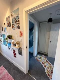 Bright, welcoming hallway with decorative photo...