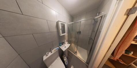 Modern tiled bathroom with a glass shower enclo...