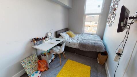 Bright, neatly arranged bedroom with a comforta...