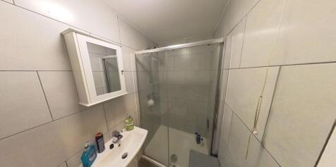 Compact, modern bathroom with a glass shower en...
