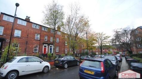Tree-lined residential street with terraced bri...
