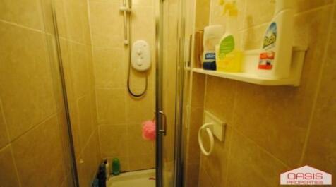 Compact tiled bathroom with a shower cubicle, w...