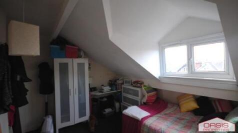 Cozy attic bedroom with a sloped ceiling, comfy...