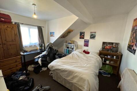 A cozy bedroom featuring a double bed with a wi...