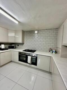 Modern, clean kitchen with white cabinetry and ...