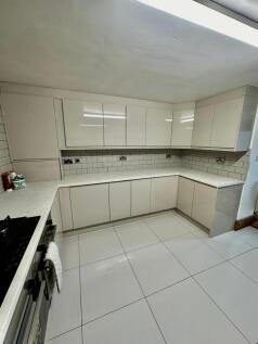 Modern and clean kitchen with ample white cabin...