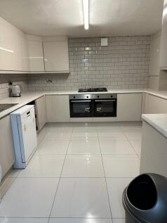 A modern, bright kitchen with white cabinetry a...