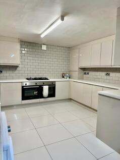 A modern, clean kitchen with white cabinetry an...