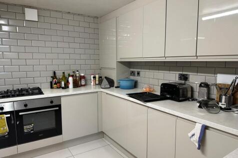 Modern and clean kitchen with white cabinetry, ...