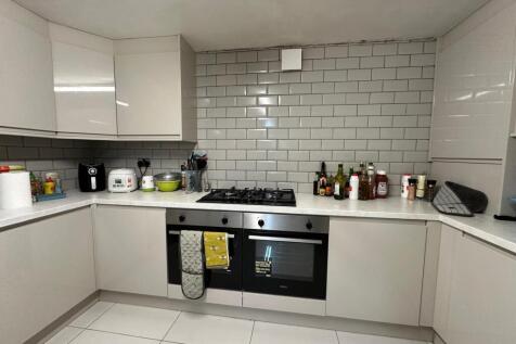 A modern, clean kitchen with white cabinets and...