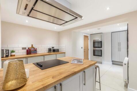 Bright modern kitchen with a central wooden isl...