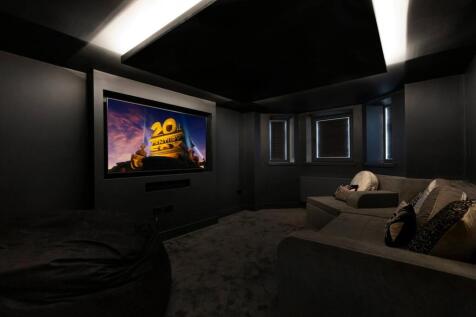 Dark, stylish private cinema room with a large ...