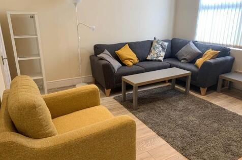 Bright, neatly furnished lounge with a comforta...