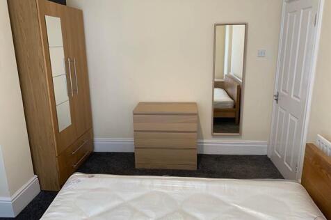 Bright, simply furnished bedroom with a double ...