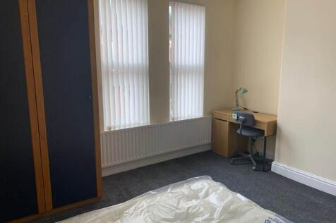 Bright, simply furnished bedroom with large win...