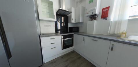 Bright, modern galley kitchen with integrated o...