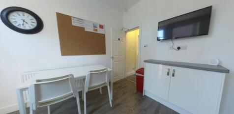 Bright, tidy communal workspace with a long des...