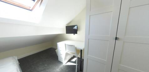 Bright attic-style single bedroom with a skylig...