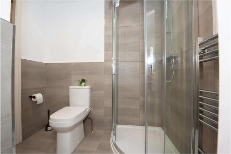 Modern bathroom with a corner glass shower encl...