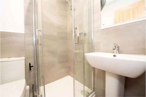 Bright, modern bathroom featuring a glass-enclo...